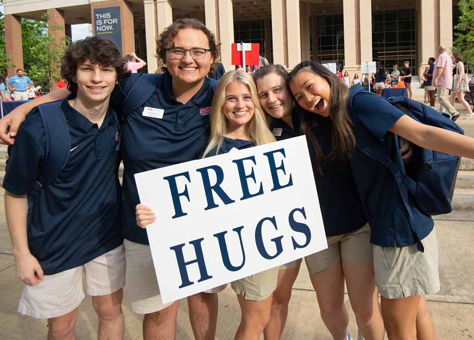 Ole Miss orientation leaders offer free hugs to new students in front of the student union during summer orientation.