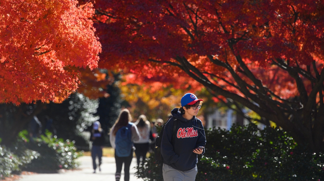 A student walks through the Ole Miss campus during a fall day.