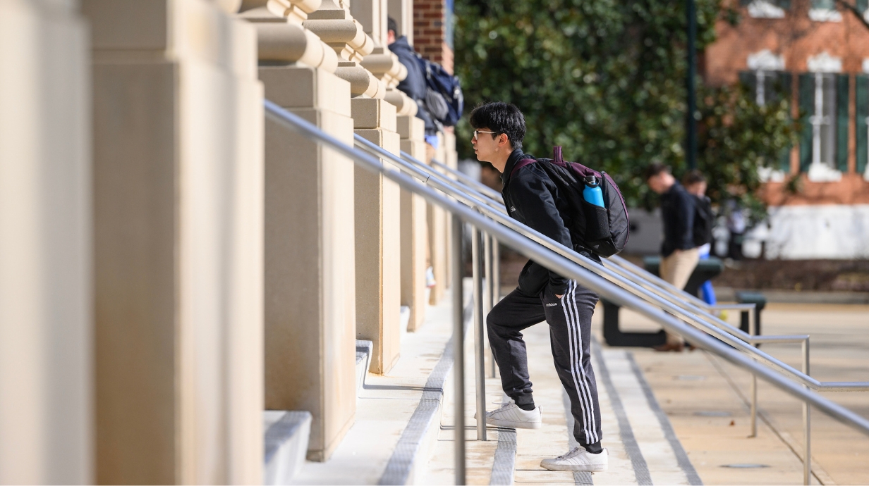 Student walking up stairs into a building. 
