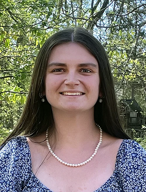 person standing outdoors smiling at the camera