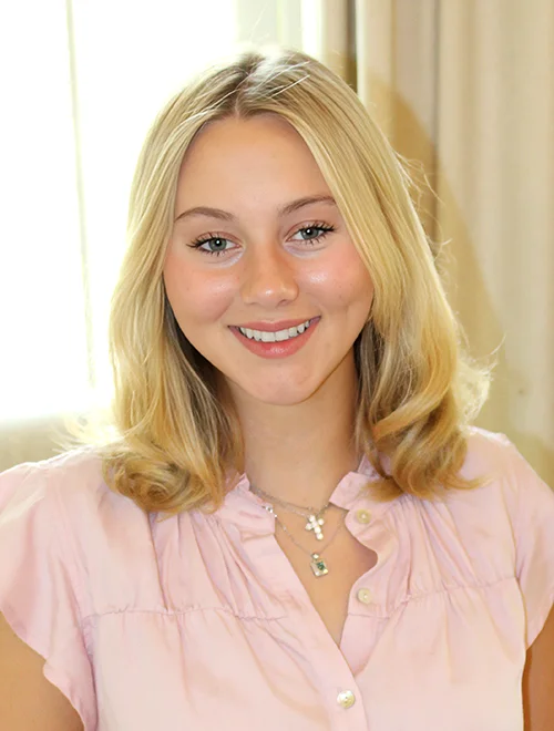 person in pink shirt smiling at camera