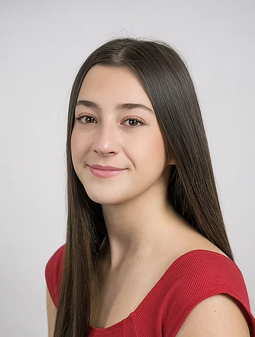 person with long straight hair smiling at camera