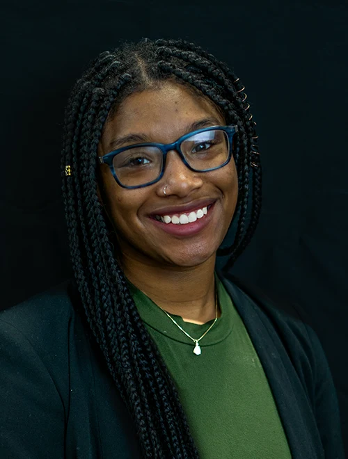 Formal portrait of Brianna Davis with black bakground.