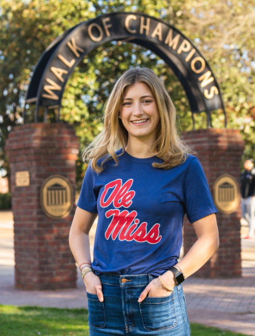 Carolyn Hale standing in front of the Walk of Champions in the Grove