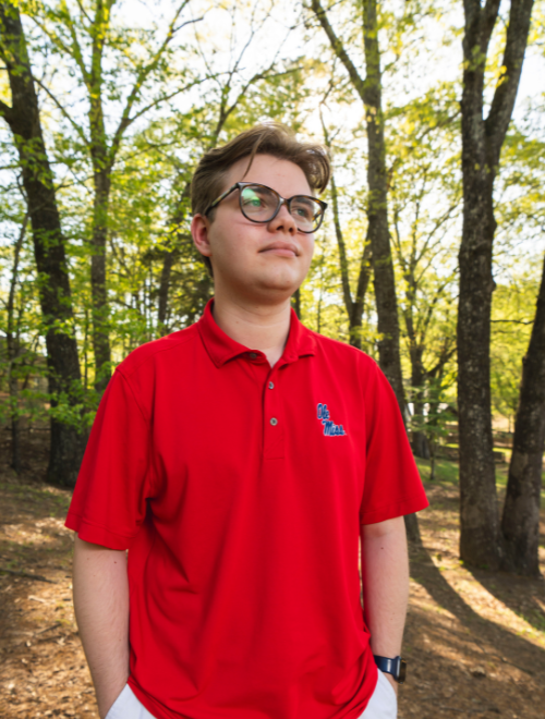 Jack standing in the woods off campus.
