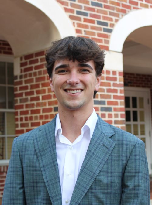 Tack Mahaffey stands in front of a brick building