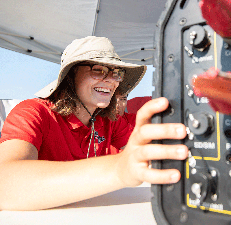 student smiling while working on land survey materials