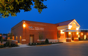Brick exterior of FedEx Academic Support Center at night.