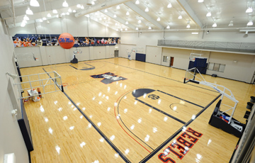 Inside view of the Tuohy Basketball Center. Brightly lit basketball court is shown. 