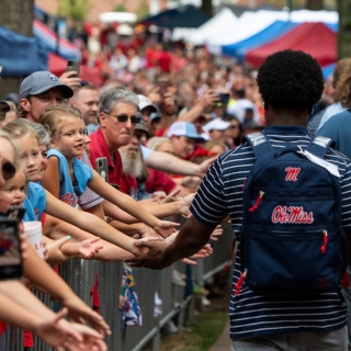 Fans look on as an Ole Miss football player takes part in the Walk of Champions
