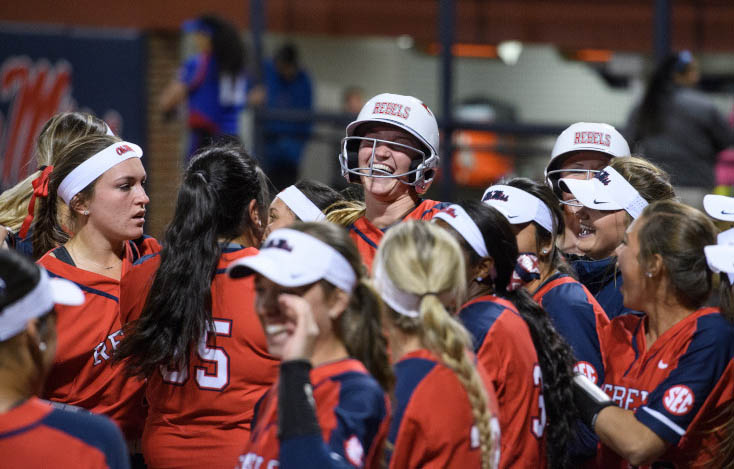 Softball players celebrate together during a game
