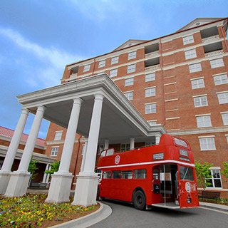 Red bus in front of the Inn at Ole Miss (red brick building).