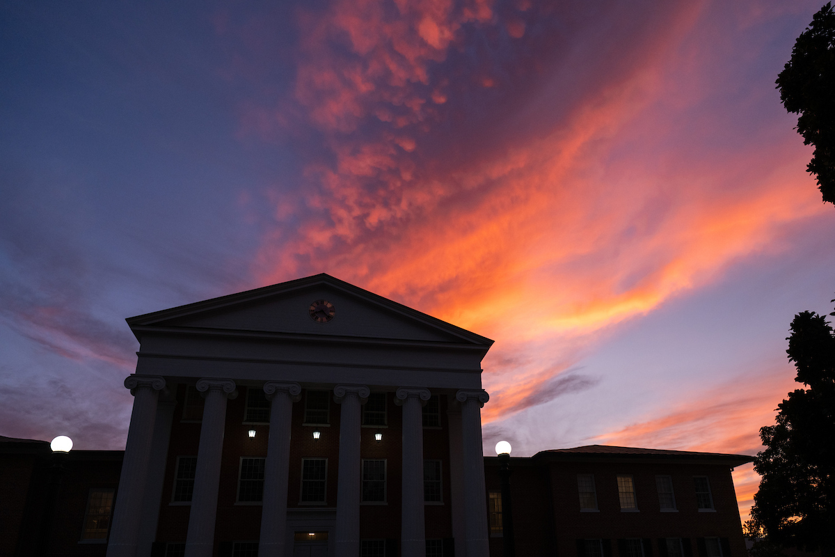 Lyceum building with a sunset behind the building
