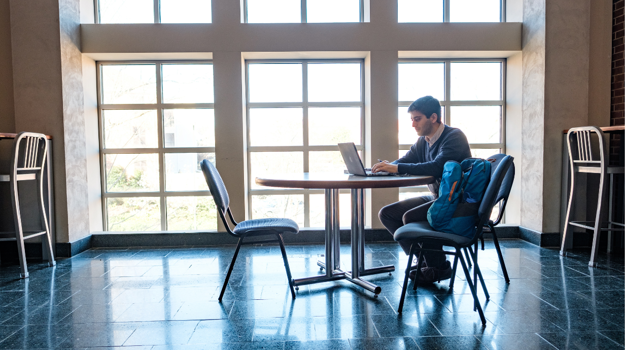 How to choose an online graduate degree. Online student works on his computer. 