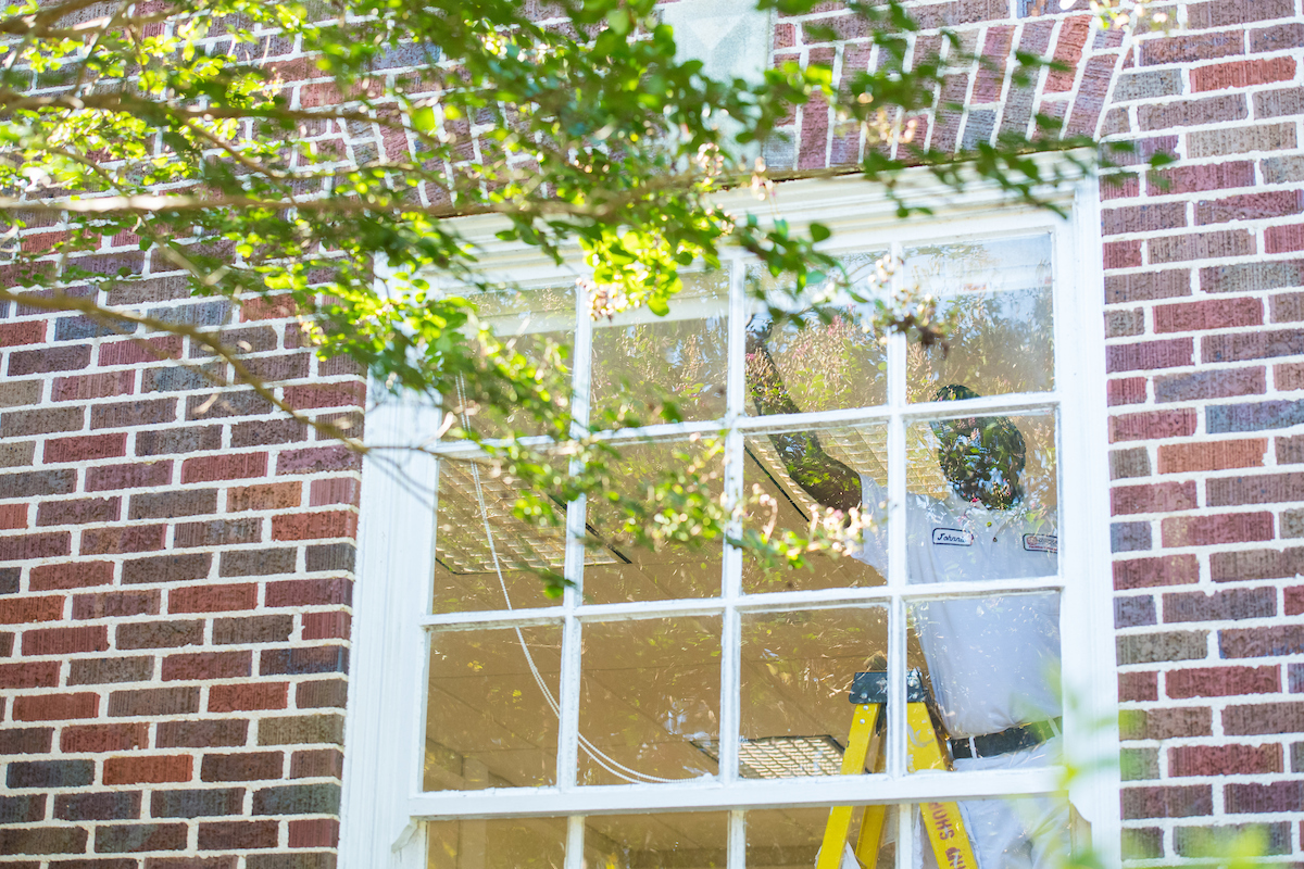 Man painting a window seal