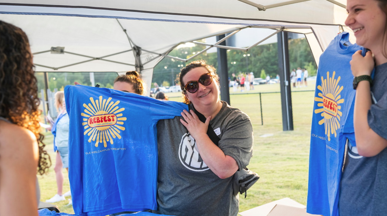 An employee holds up a t-shirt at RebelFest 2024