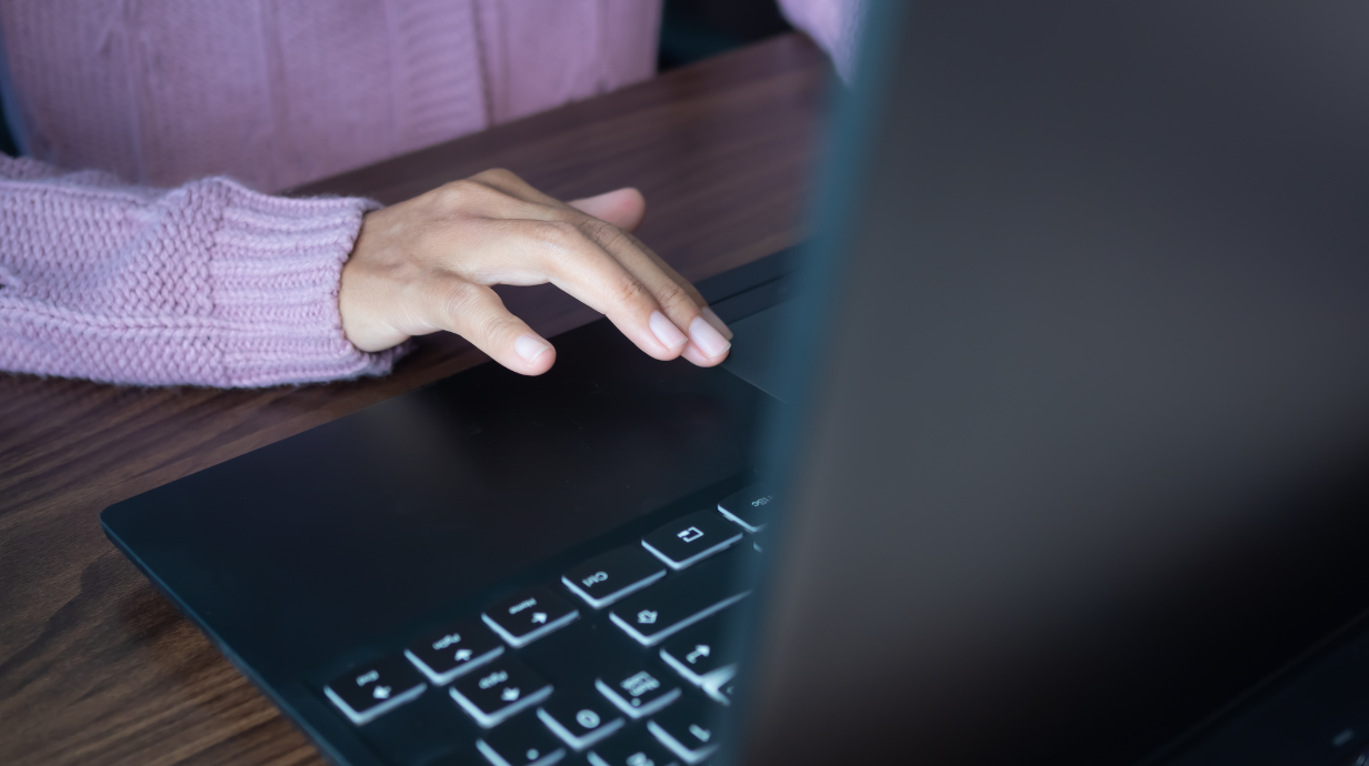 Woman in purple sweater working on her laptop