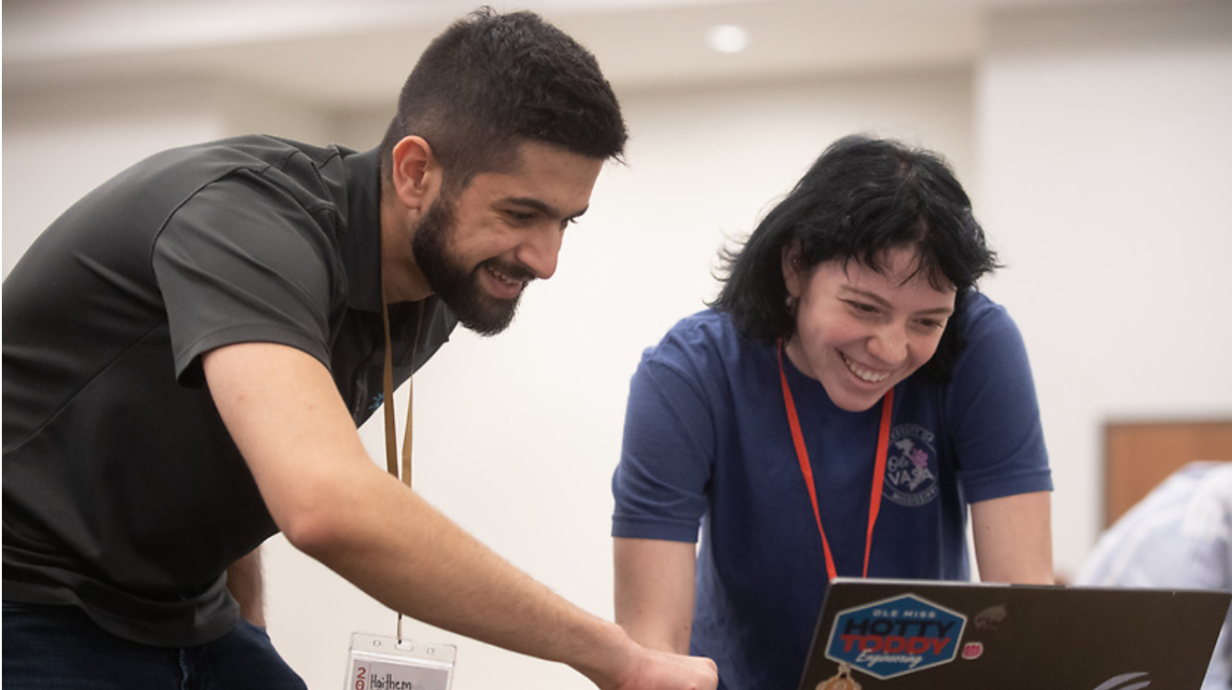 A student and faculty member look at a computer together.