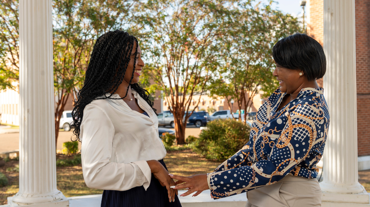 Photo of two staff members embracing one another.