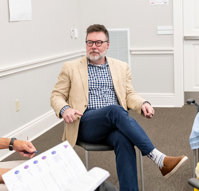 Steven Holley listens to other staff members during a meeting.