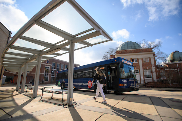 Student in front of University bus 