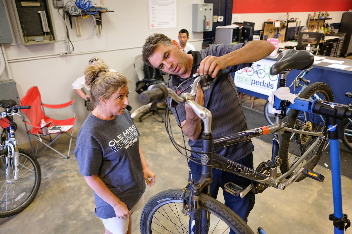 Man demonstrating a service on a bike for a customer