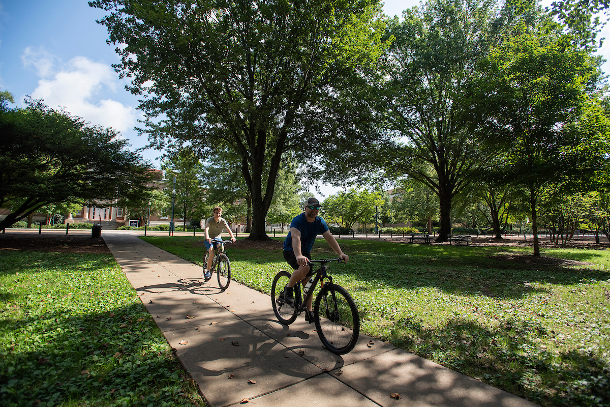 Two people riding bikes on Ole Miss Campus