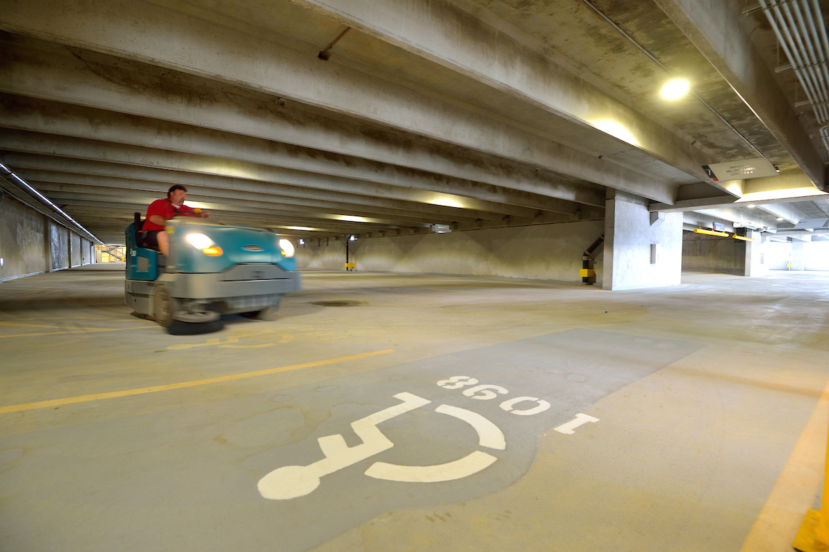 Employee cleaning area by handicap parking