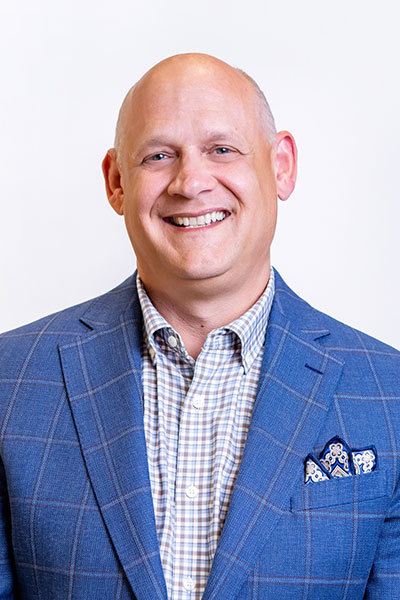 Headshot of Adam Black in a striped blue blazer.