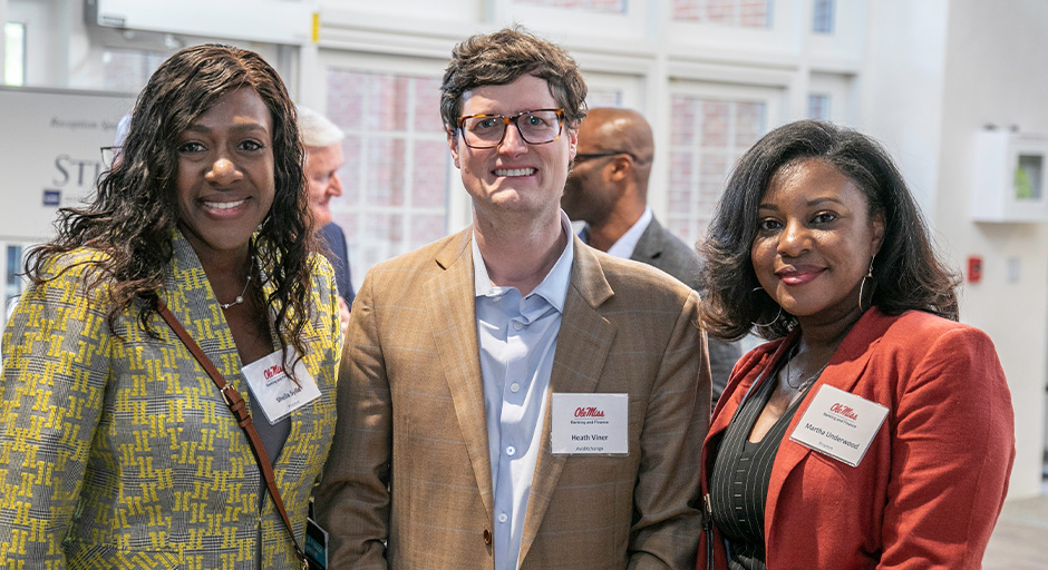 A male and two females posing for a photo during the symposium.