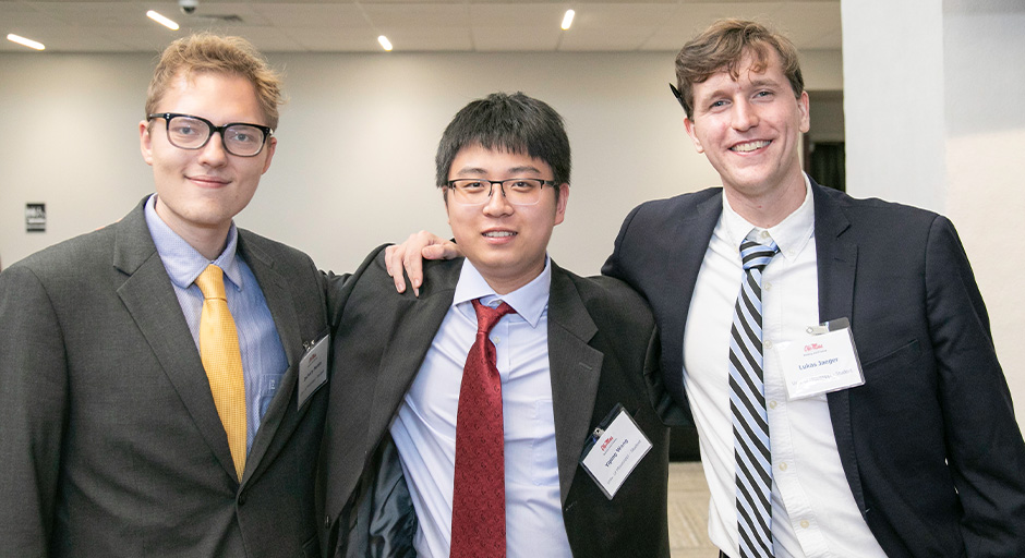 Three young men pose for a group photo during the symposium.