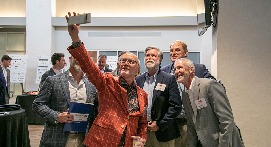 A group of men taking a selfie during the symposium.