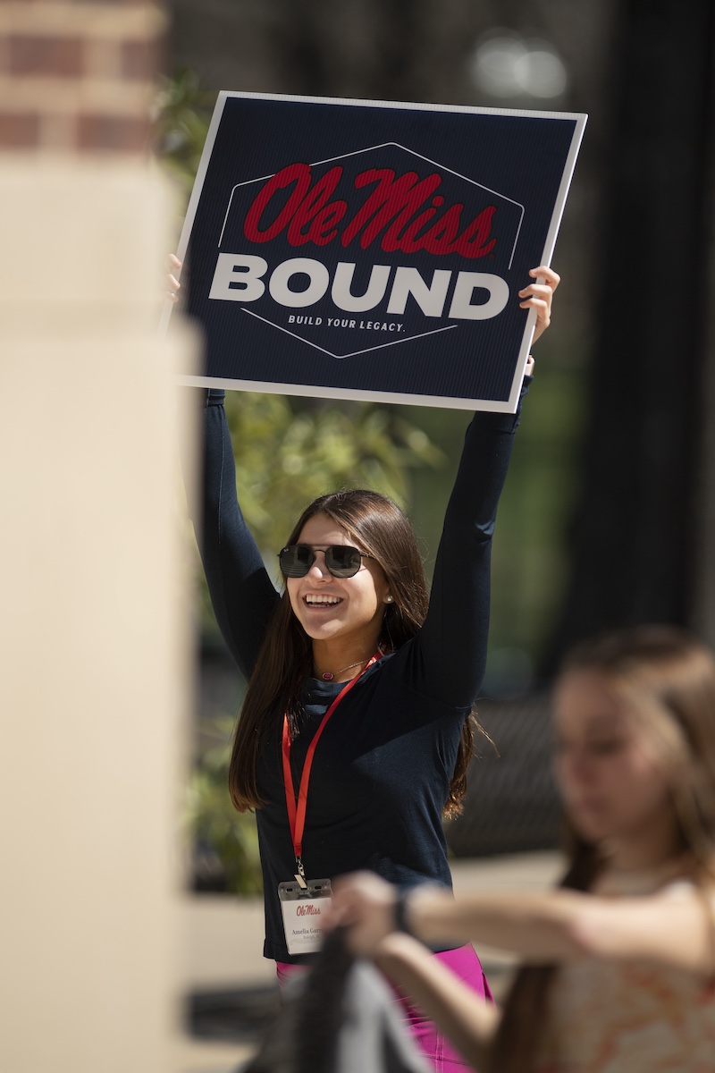 Student holding a sign that says Ole Miss Bounds, Build your legacy