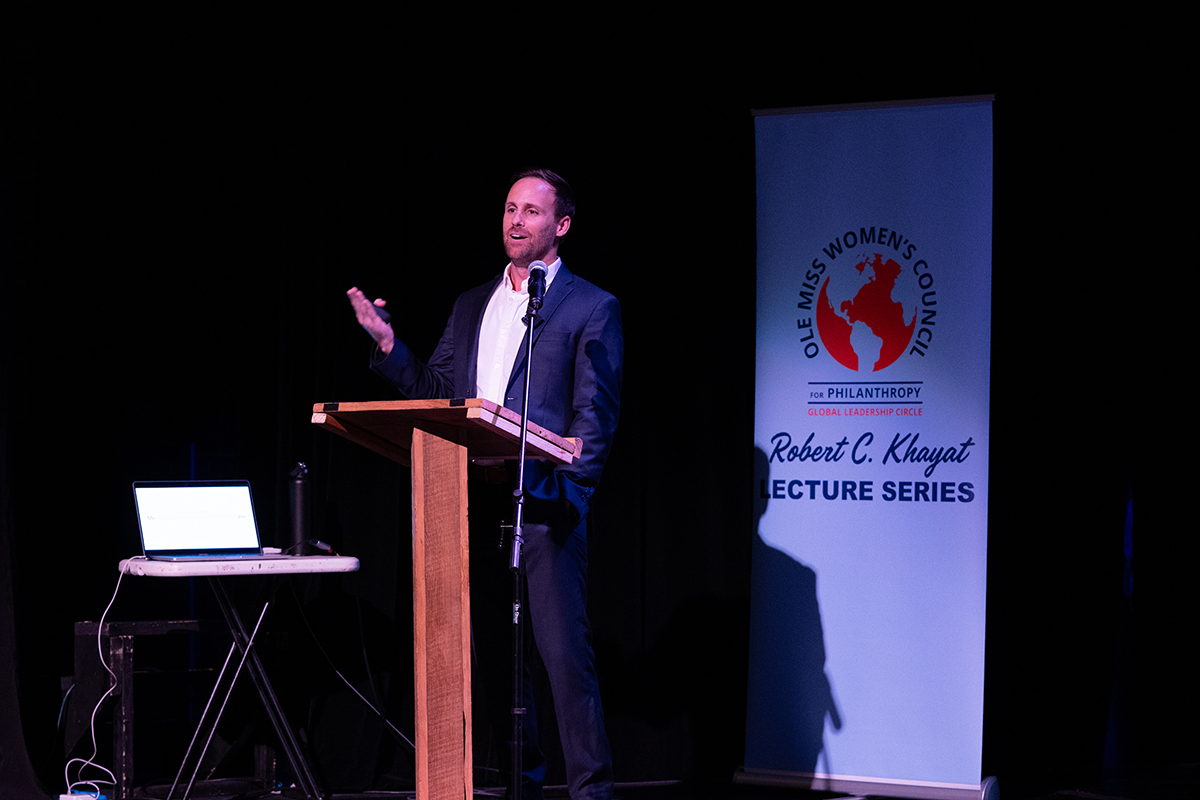 man at a podium talking to a crowd
