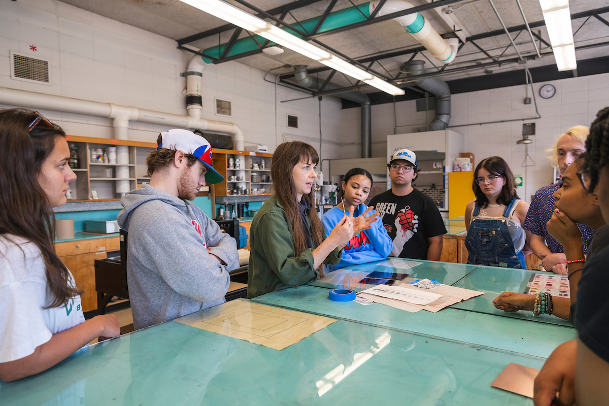 Teacher talks to students in an art class. 