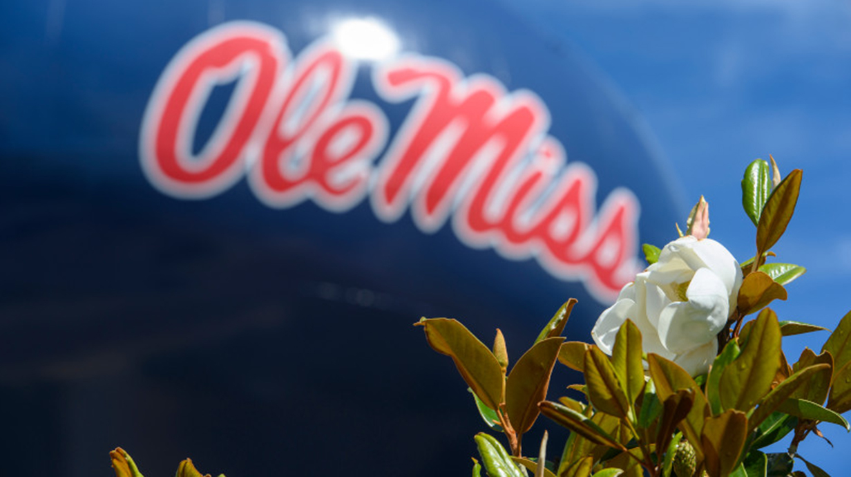 A magnolia leaf in the foreground with the iconic Ole Miss water tower in the background