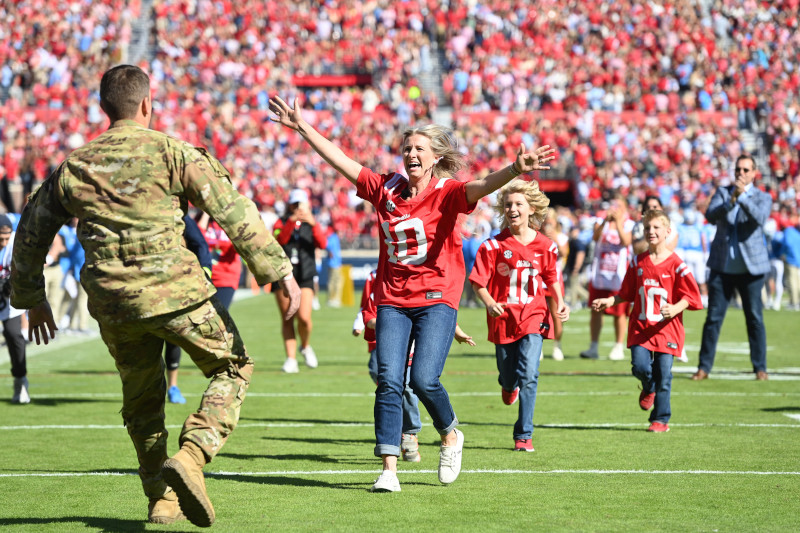 Family embracing on the sidelines of a football game