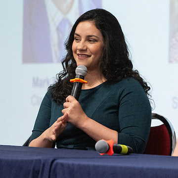 Panelists speak into the microphone during a previous UMC3 Summit