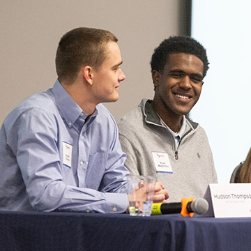 Panelist Hudson Thompson and Ryan Augustine share thoughts from a stage during the 2024 UMC3 Summit