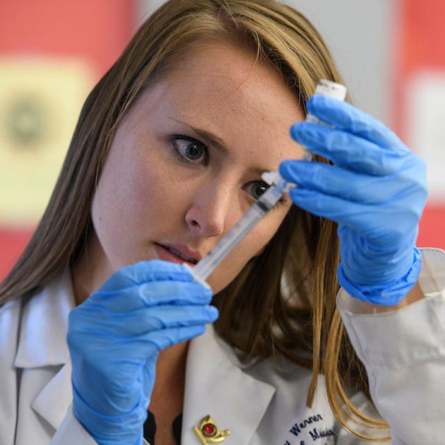 Student pulls medicine into a syringe.