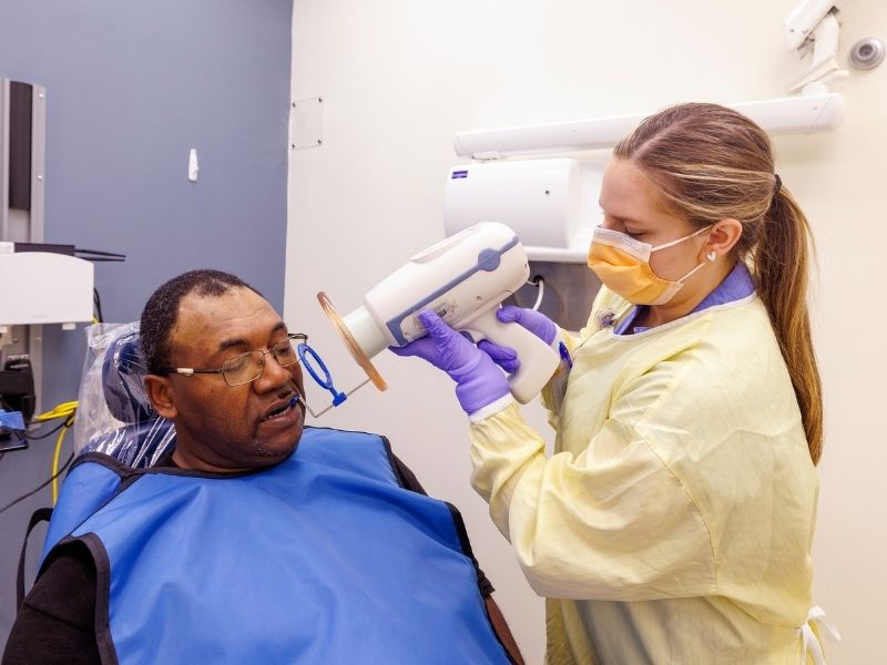 Dental Hygiene student Emily Barnes takes x-rays of Boyland's teeth during Dental Mission Week.