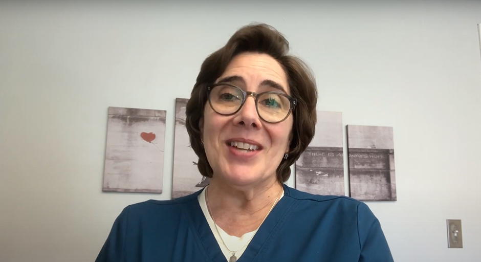 short brown haired woman with glasses and dark blue scrub shirt