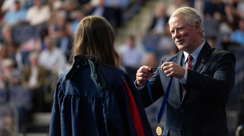 Glenn Boyce presents a medal to a recent graduate
