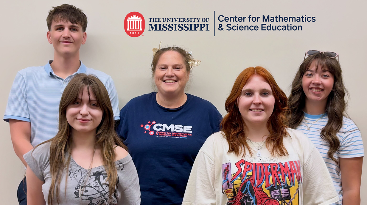 Five CMSE student workers smiling at the camera for a group photo with the official CMSE logo above their heads.