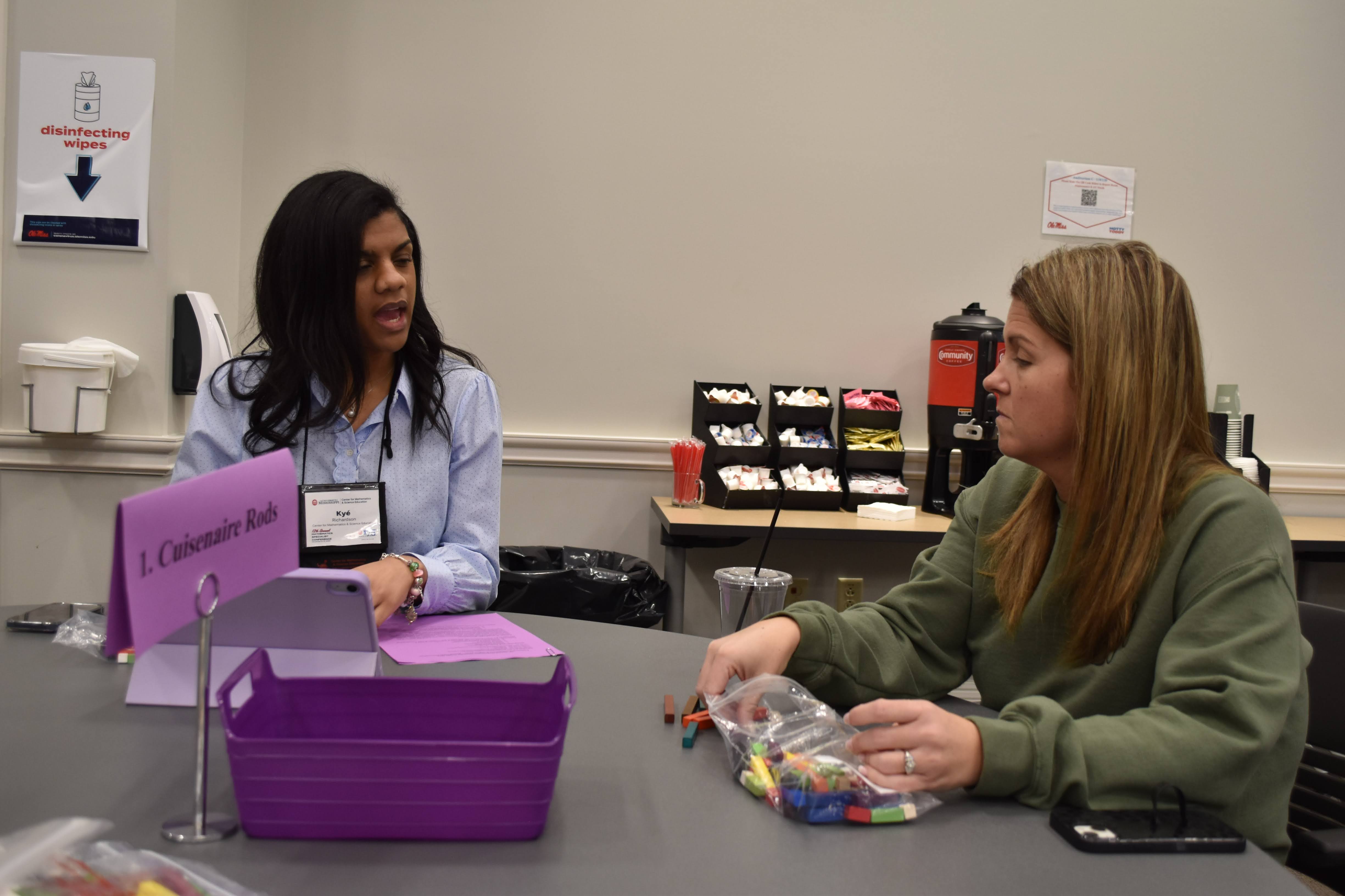 Two teachers explore manipulatives.