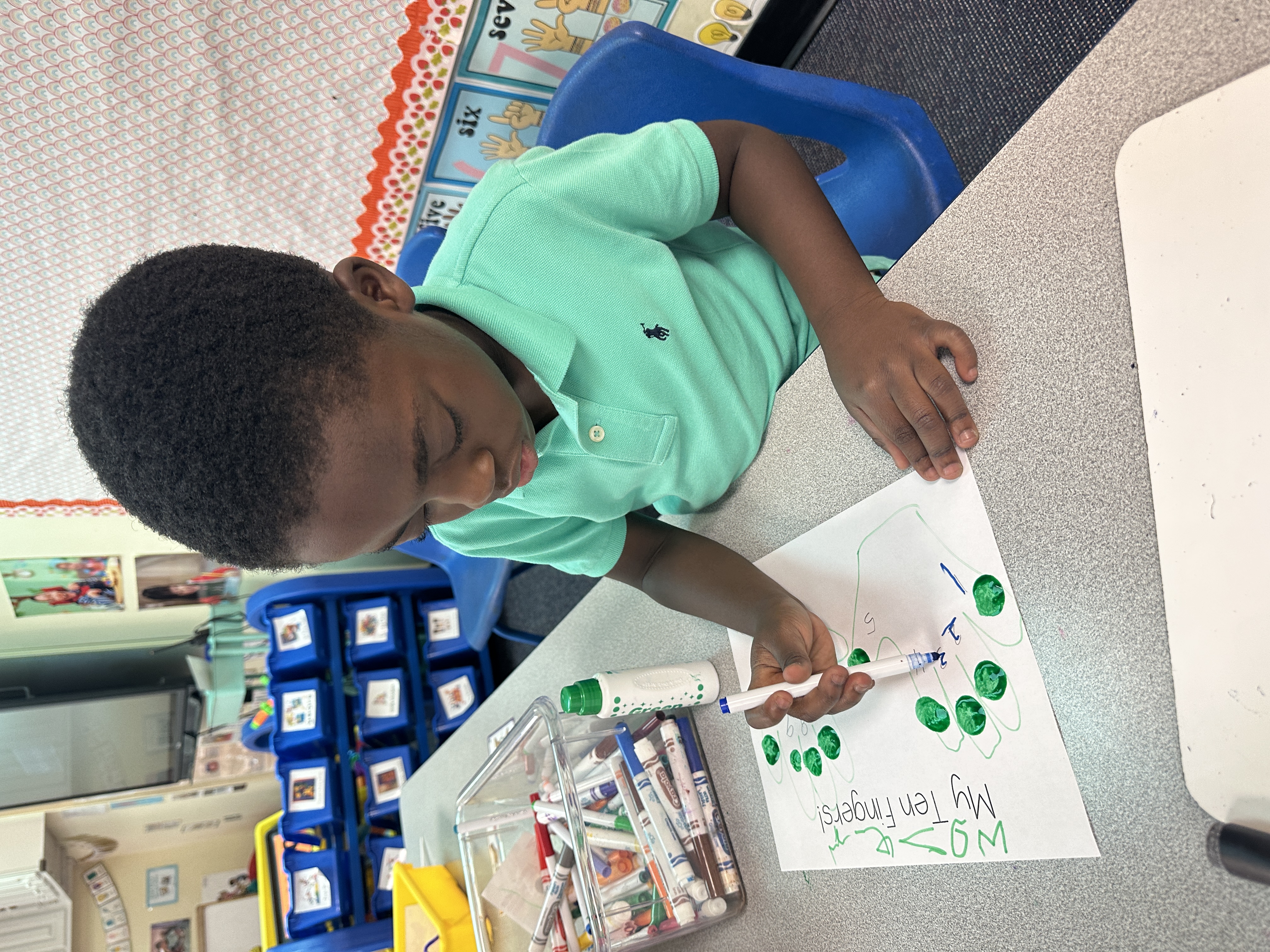 A student colors and labels numbers on a worksheet.