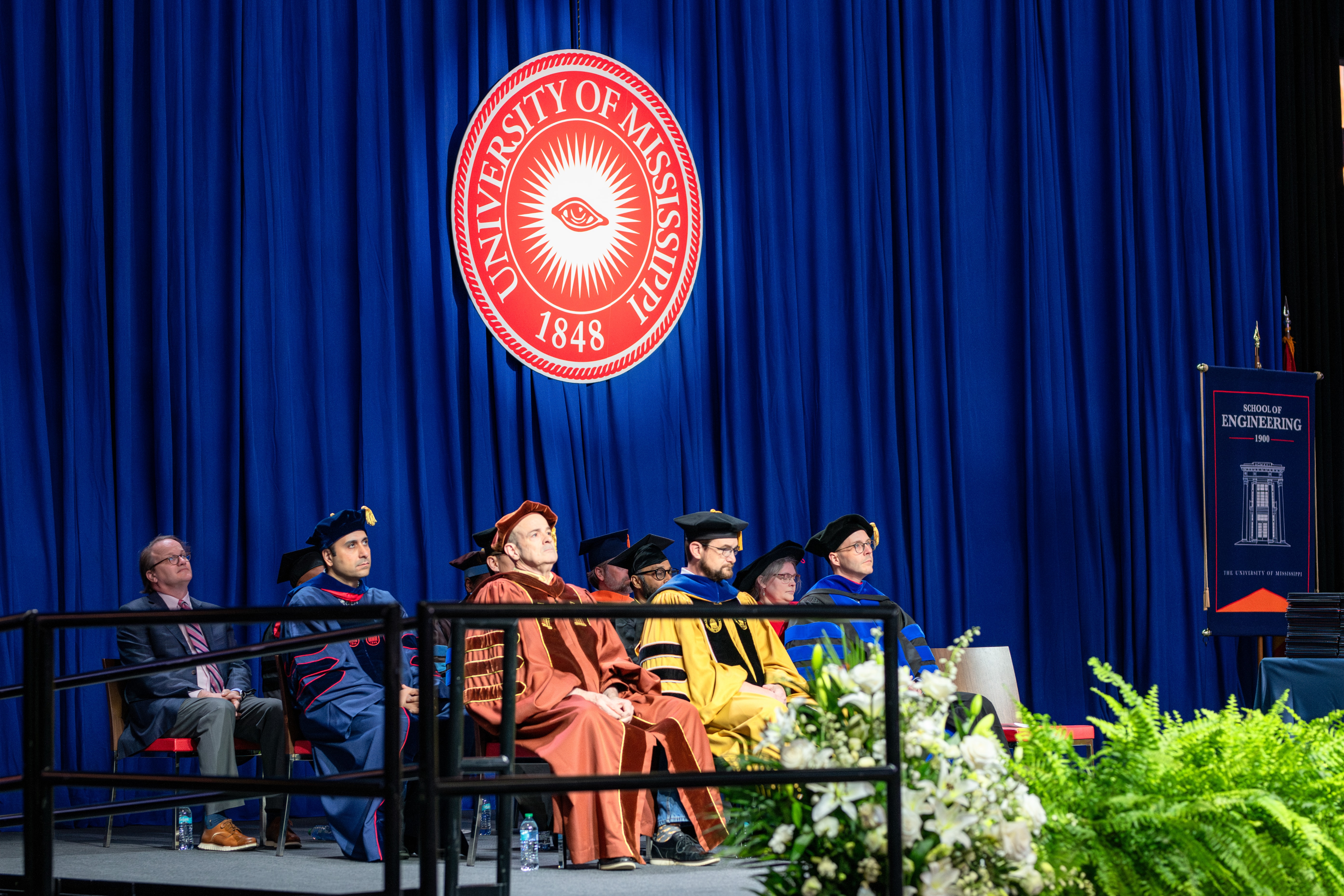 Engineering faculty seated on stage during a graduation ceremony