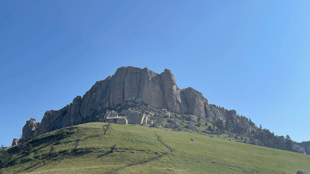 A large rock formation at the top of a hill.