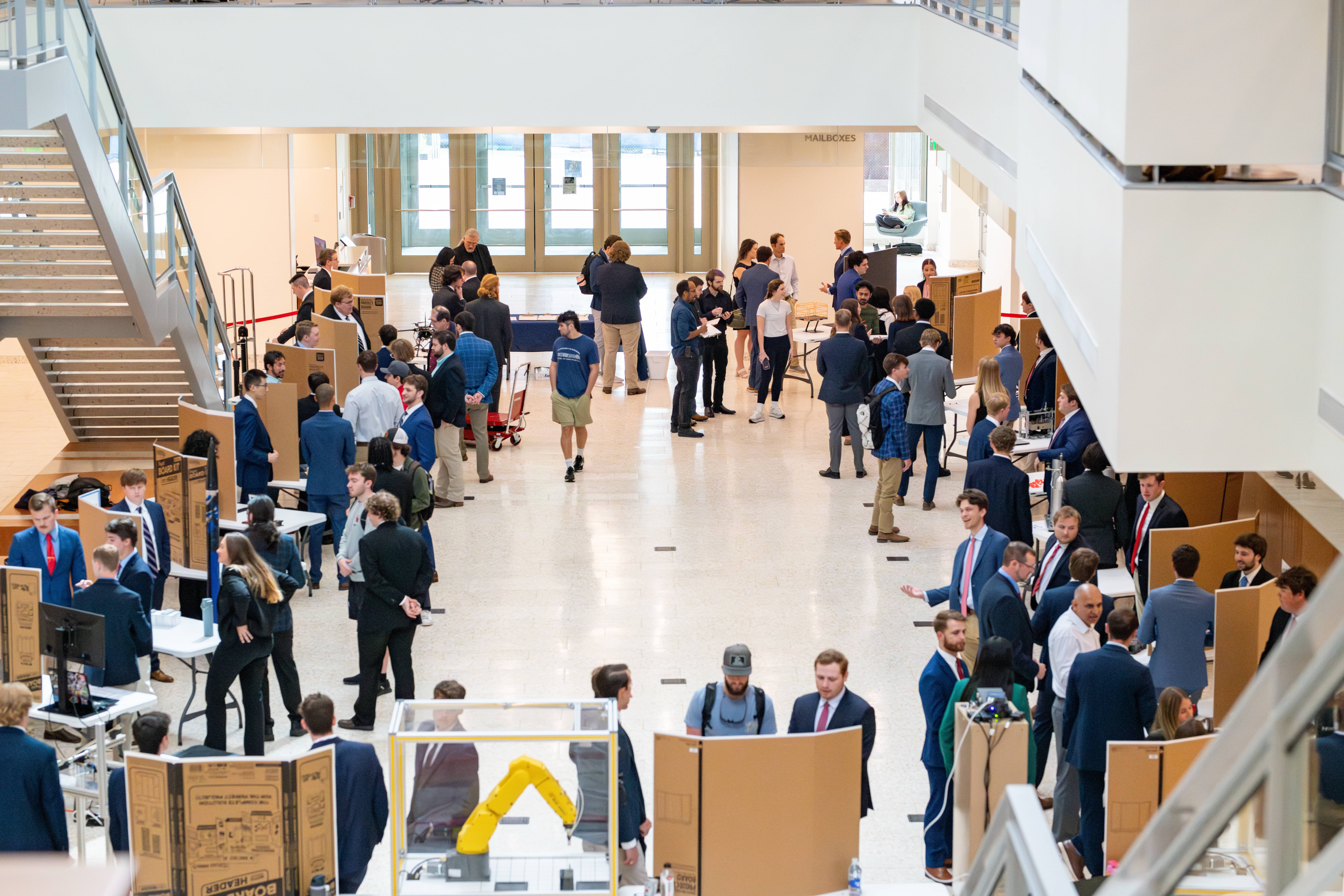 A overhead shot of a large group of students presenting their senior mechanical engineering projects in the Duff Center