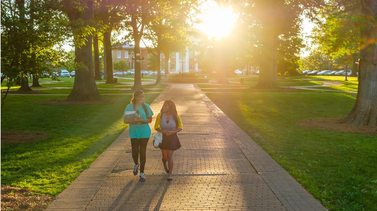 Two Ole Miss students walk through the Circle at sunset.